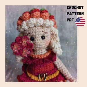 May include: A crochet doll with light skin, blonde hair, and a red dress featuring a gold Virgo symbol. The doll wears a hat adorned with orange and red berries and holds a cluster of red flowers. Text reads CROCHET PATTERN PDF with a US flag.