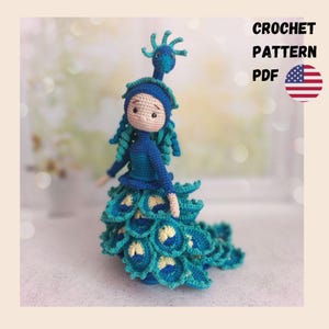 May include: Crochet pattern PDF for a blue and green peacock doll. The doll has a blue dress and a peacock tail made of crocheted feathers.