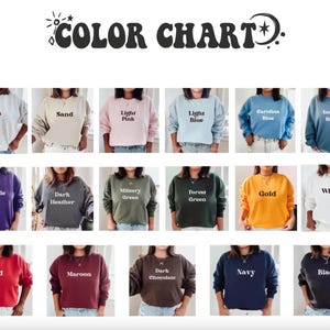 K&ouml;nnte beinhalten: Eine Farbkarte mit achtzehn Rundhals-Sweatshirts in verschiedenen Farben, darunter Ash, Sand, Light Pink, Light Blue, Carolina Blue, Indigo Blue, Purple, Dark Heather, Military Green, Forest Green, Gold, White, Red, Maroon, Dark Chocolate, Navy und Black.