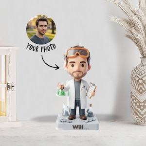 Puede incluir: Figura de un científico con bata blanca, sosteniendo un vaso de precipitados con líquido verde y una carpeta. La figura tiene gafas naranjas y está sobre una base con "Will..." y una foto de un hombre. El texto "YOUR PHOTO" también está presente.