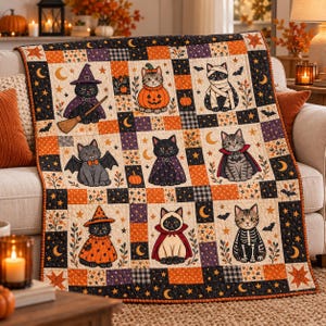 Op de afbeelding: Een quilt met Halloween-thema bestaande uit een raster van negen vierkanten, elk met een andere kat in kostuum, waaronder een heks, pompoen, mummie, vleermuis, vampier en skelet, omringd door oranje, zwarte en crèmekleurige patronen.