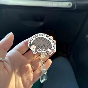 Bobine drôle d'insigne d'opossum « fera le mort pour éviter les gens » Cadeau mignon d'infirmière introvertie Titulaire d'une pièce d'identité d'enseignant Accessoire d'humour de bureau rétractable