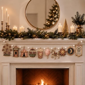 Op de afbeelding: Een decoratieve slinger met miniatuurornamenten in kermisthema, waaronder een reuzenrad, een loket, een circustent, een heteluchtballon, een popcornemmer, suikerspin, een carrouselpaard, een ster, een maan en een banier met de tekst Life is Better at the Top.