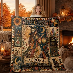 May include: A rectangular quilt featuring a central illustration of a witch holding a lantern, surrounded by panels depicting a sunflower, a house, a potion bottle, a broom, a sun, a moon, crystals, a cauldron, a book, and a black cat. The name AURORA is printed on a banner at the bottom.