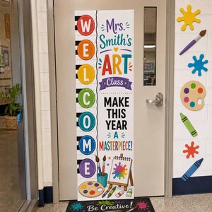 May include: A vertical door banner featuring the word WELCOME in colorful circles, with the text Mrs. Smith's ART Class, MAKE THIS YEAR A MASTERPIECE!, and illustrations of paintbrushes, a paint palette, and an easel on a white background.