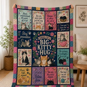 May include: A multi-colored patchwork quilt featuring various cat illustrations and text including "Sending you a big kitty hug," "Stay pawsitive," and "You are purr-fect." The design incorporates floral patterns, hearts, and paw prints in shades of blue, pink, yellow, and green.