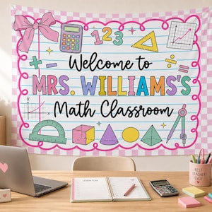 May include: A rectangular fabric wall hanging featuring a lined paper background with a pink checkered border. It displays the text Welcome to MRS. WILLIAMS'S Math Classroom, surrounded by colorful math icons like a calculator, shapes, and a bow.