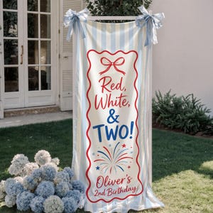 May include: A banner with a red, white, and blue theme, perfect for a second birthday celebration. The banner features the text "Red, White, & TWO!" and "Oliver's 2nd Birthday!" in a decorative font. It is decorated with fireworks and a bow.