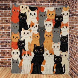 May include: A quilted blanket featuring a repeating pattern of cartoon cats in various colors including black, white, orange, and gray. Each cat has large eyes and a simple facial expression, arranged in a dense, overlapping grid across the fabric.