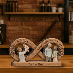 May include: A wooden infinity sculpture with the words "Dad & Daughter" and "A bond that can never be broken." The sculpture features figures of a father and daughter, and a couple. The base reads "Dad & Emily."