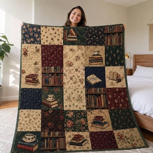 Puede incluir: Una colcha de retazos rectangular con un patrón de cuadrícula repetitivo. El diseño incluye bloques alternos de estampados florales en tonos burdeos, crema y verde oscuro, junto con ilustraciones de libros apilados y tazas de té.