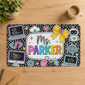 May include: A rectangular desk mat featuring a black background with white cross patterns. The center displays the text Ms. PARKER on a lined paper graphic, surrounded by illustrations of laptops, a robot, a bow, a mouse, and coding symbols.