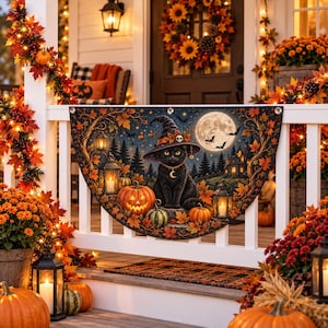 May include: A semi-circular decorative banner featuring a black cat wearing a witch hat, surrounded by pumpkins, lanterns, and autumn leaves under a full moon. The design includes a dark forest background and is mounted on a white porch railing.