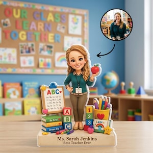 Pode incluir: Uma figura de acrílico personalizada de um professor com cabelos longos e ondulados, vestindo uma camisa de manga comprida verde-azulada e calças bege, segurando uma maçã vermelha. A base apresenta o texto Ms. Sarah Jenkins Best Teacher Ever.