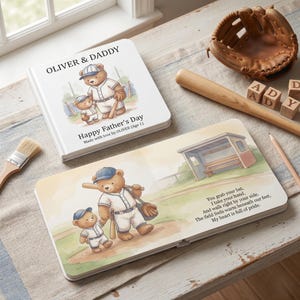 May include: A children's book with a baseball theme. The cover reads "OLIVER & DADDY" and "Happy Father's Day." Inside, illustrations depict teddy bears playing baseball. A baseball glove, bat, and wooden blocks spelling "DAD" are also present.