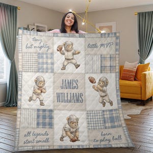 May include: A personalised patchwork quilt with a football theme. The quilt features a repeating pattern of teddy bears in football uniforms, interspersed with squares of blue and white plaid and text that reads "tiny but mighty", "little MVP", "all legends start small", and "born to play ball". The name "JAMES WILLIAMS" is also featured.