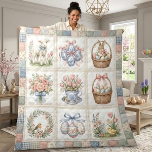 May include: A pastel-coloured, quilted blanket with Easter-themed illustrations. The design features a lamb, decorated eggs, a bunny in a basket, floral arrangements, and a chick. The border has a patchwork design in soft colours.