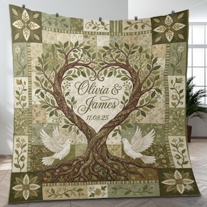 May include: A personalized quilt featuring a tree design with a heart-shaped canopy. The quilt has a patchwork pattern in shades of green and beige, with the names "Olivia & James" and the date "11.08.25" displayed. Two white doves are perched on the tree.
