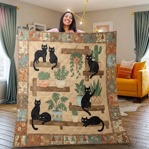 May include: A beige quilt featuring a design of black cats on wooden shelves with potted plants. The quilt has a quilted pattern and a decorative border with floral and geometric elements. The cats are in various poses.