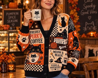 May include: A black, orange, and cream button-down cardigan featuring various cat-themed graphics, including text that reads Freshly Purr'd Coffee, Black Cat Cafe, and Meow & Magic, alongside illustrations of cats, coffee cups, and witch hats.