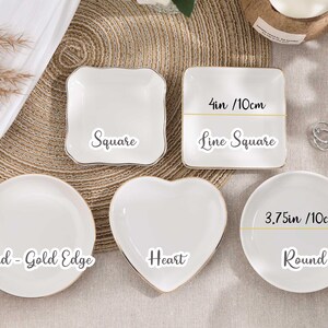 May include: A selection of white ceramic dishes in different shapes: square, heart, and round. The square dish is 10cm wide. The round dish is 10cm wide. Each dish has a gold edge and is labelled with its shape.