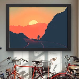 Könnte beinhalten: Gerahmter Kunstdruck, der einen Radfahrer auf einer Straße bei Sonnenuntergang zeigt. Das Kunstwerk zeigt eine Silhouette eines Radfahrers, einen leuchtend orangefarbenen Himmel und dunkelblaue Bergsilhouetten. Der Druck wird über Fahrrädern angezeigt.