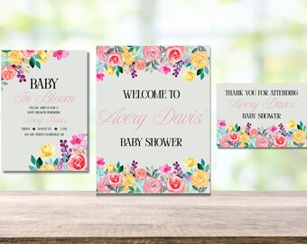 May include: Three baby shower signs with floral designs. The signs read "Baby in Bloom", "Welcome to Avery Davis' Baby Shower", and "Thank You for Attending Avery Davis' Baby Shower". The signs feature pink, yellow, and purple flowers.