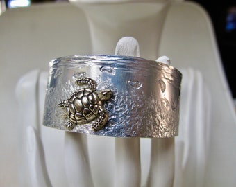 Baby Sea Turtle Cuff Bracelet - Very Pretty- on some customers screen the turtle appears gold, it is silver in color.  No gold or blue color