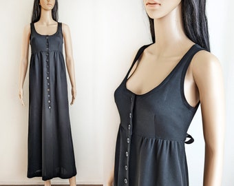 Può includere: Un abito maxi nero senza maniche con chiusura a bottoni sul davanti e un corpetto aderente. L'abito ha una gonna leggermente svasata e un design semplice ed elegante.