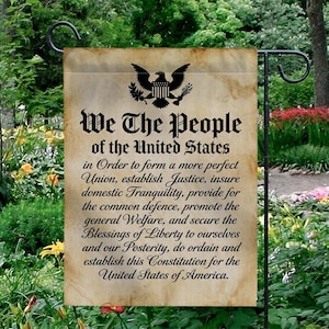Könnte beinhalten: Eine Gartenflagge mit dem Text "We The People of the United States" und der Präambel der US-Verfassung. Die Flagge hat ein Vintage-Pergament-Design mit einem schwarzen Adler-Emblem.