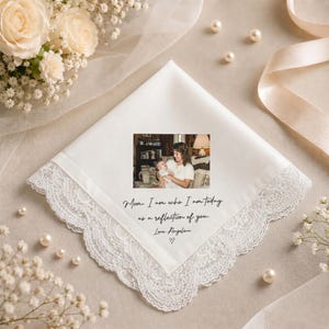 May include: White handkerchief with a delicate lace trim. A small photo of a mother and baby is printed on the handkerchief, along with the text "Mom, I am who I am today as a reflection of you. Love Angelina." Pearls and flowers surround the handkerchief.