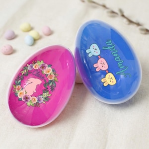 May include: A white ceramic mug with a colorful floral design. The mug features a variety of flowers in shades of pink, purple, and yellow, with green leaves. The mug has a curved handle and a glossy finish.