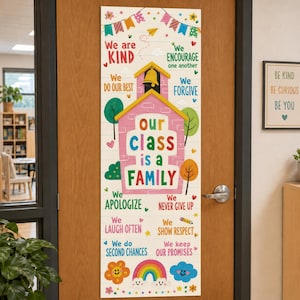 May include: A vertical classroom door banner featuring a pink schoolhouse illustration and the text Our class is a family. It includes colorful graphics of bunting, trees, hearts, a rainbow, and positive phrases like We are kind and We do our best.