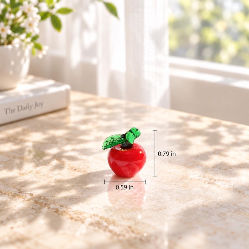May include: A miniature red glass apple figurine with a green glass leaf. The apple measures 0.59 inches in width and 0.79 inches in height, as indicated by the visible measurement lines and text labels on the image.