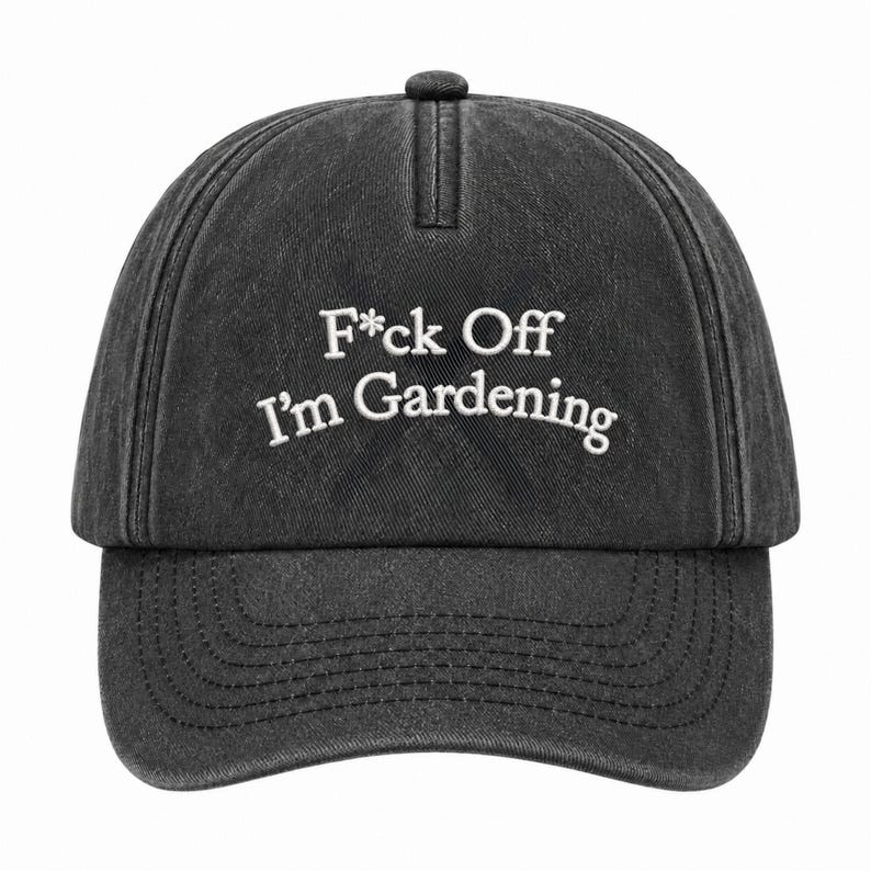 Peut inclure: Une casquette de baseball gris anthracite avec une texture d&eacute;lav&eacute;e et us&eacute;e. L'avant pr&eacute;sente un texte brod&eacute; en blanc qui indique F*ck Off I'm Gardening dans une police sans empattement. La casquette a une calotte structur&eacute;e et une visi&egrave;re.