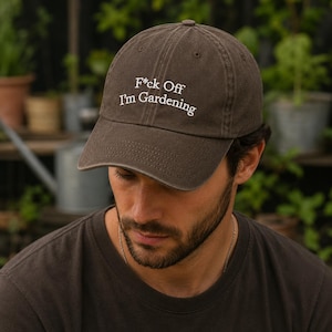 Peut inclure: Une casquette de baseball marron fonc&eacute; avec le texte brod&eacute; en blanc F*ck Off I'm Gardening centr&eacute; sur le panneau avant. La casquette pr&eacute;sente une visi&egrave;re incurv&eacute;e, une calotte structur&eacute;e avec des &oelig;illets d'a&eacute;ration et six panneaux.