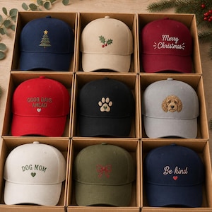 Puede incluir: Nueve gorras de béisbol en compartimentos de cartón individuales. Los diseños incluyen un árbol de Navidad, acebo, el texto Merry Christmas, Good Days Ahead, una huella, un retrato de perro, el texto Dog Mom, un lazo rojo y Be Kind.
