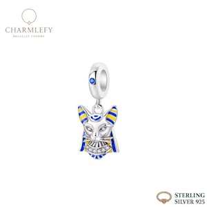May include: A sterling silver charm with a cat-like face, featuring blue and yellow accents. The charm has a loop for attaching to a bracelet. The charm is from the brand Charmlefy.