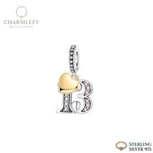 Könnte beinhalten: Ein Sterling Silber Charm mit der Zahl 13, verziert mit klaren Kristallen und einem goldenen Herz. Der Charm hat eine Schlaufe zum Befestigen an einem Armband. Der Markenname "Charmlefy" ist oben links sichtbar.