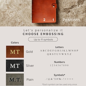 May include: A brown leather journal with two personalization options. The journal has a gold, silver, or plain embossed option. The text on the image reads "Let's personalize it CHOOSE EMBOSSING Up to 11 symbols Letters A B C D E F G H I J K L M N O P Q R S T U V W X Y Z Numbers 1 2 3 4 5 6 7 8 9 0 Symbols* . / @ & ' $ # № - ! >> << *Each symbol can be used only once Heads up! If you forget to choose a personalization placement, we'll go with the default one - Position 1"