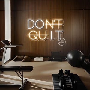 May include: A neon sign in a gym reads "DON'T QUIT" in white and orange. The sign is mounted on a wood-paneled wall. The gym also features exercise equipment, including a treadmill, weights, and a black exercise ball.