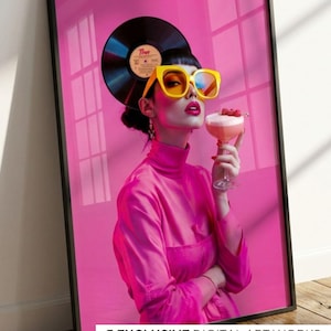 Puede incluir: Una impresión artística digital enmarcada que muestra a una mujer con gafas de sol amarillas y un atuendo rosa, sosteniendo un cóctel. Un disco de vinilo está detrás de su cabeza. El fondo es rosa. El texto en la parte inferior dice "5 EXCLUSIVE DIGITAL ART WORKS".