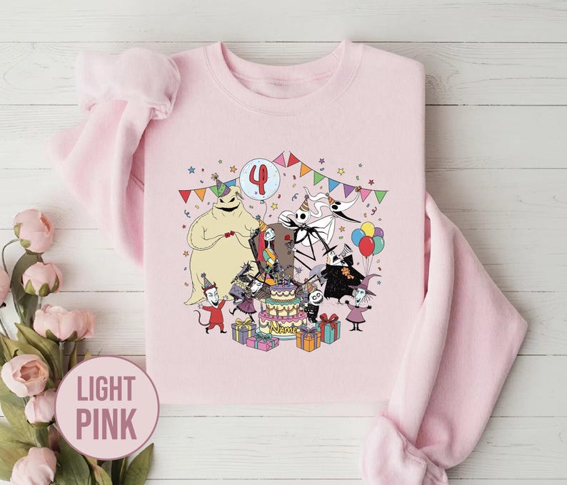 May include: Light pink sweatshirt featuring a colorful graphic of characters from The Nightmare Before Christmas celebrating a birthday. The number 4 is on a balloon. The word "Name" is on the cake. The sweatshirt is surrounded by colorful confetti and presents.