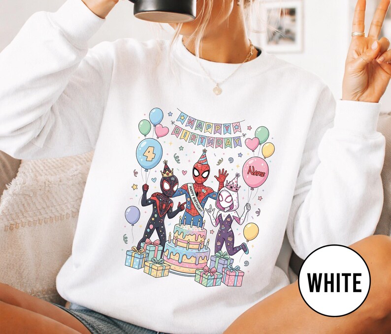 May include: White sweatshirt featuring a colorful birthday scene with Spider-Man characters. The design includes a cake, balloons, and the text "Happy Birthday." A large number 4 balloon is also present.