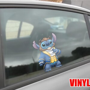 May include: A vinyl decal of Stitch dressed as Beast from Beauty and the Beast, applied to a car window. Stitch is depicted in a blue suit with a yellow vest and a white ruffled shirt. The word "VINYL" is printed in red.