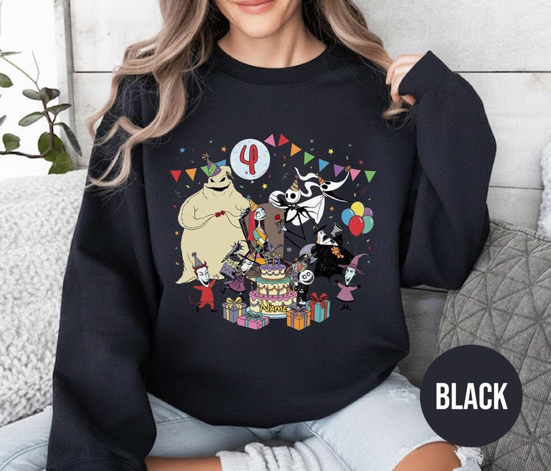 May include: Black sweatshirt featuring a colorful graphic of characters from The Nightmare Before Christmas celebrating a birthday. The design includes a cake, presents, and the number 4. The word "BLACK" is printed on a black circle.