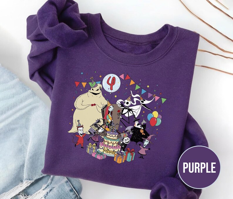 May include: Purple sweatshirt featuring a colorful graphic of characters from The Nightmare Before Christmas celebrating a birthday. The design includes a birthday cake, presents, and the number 4. The word "PURPLE" is in a circle on the bottom right.