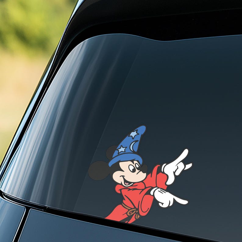 May include: A colorful vinyl decal featuring Mickey Mouse in a wizard's outfit. Mickey is wearing a blue wizard hat with stars and a red robe, pointing with both hands. The decal is designed for application on a car window.