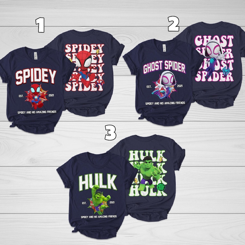 Puede incluir: Camisetas azul marino con dise&ntilde;os de superh&eacute;roes. Una camiseta dice "Spidey" con un gr&aacute;fico de Spider-Man, otra dice "Ghost Spider" y la tercera dice "Hulk". Cada camiseta tiene el texto "Spidey and his amazing friends" y el a&ntilde;o 2021.