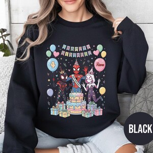 May include: Black sweatshirt featuring a colorful birthday graphic with Spider-Man characters, a cake, balloons, and the text "Happy Birthday." The number "4" is on a balloon. The word "Name" is on a balloon. The word "BLACK" is on a black circle.